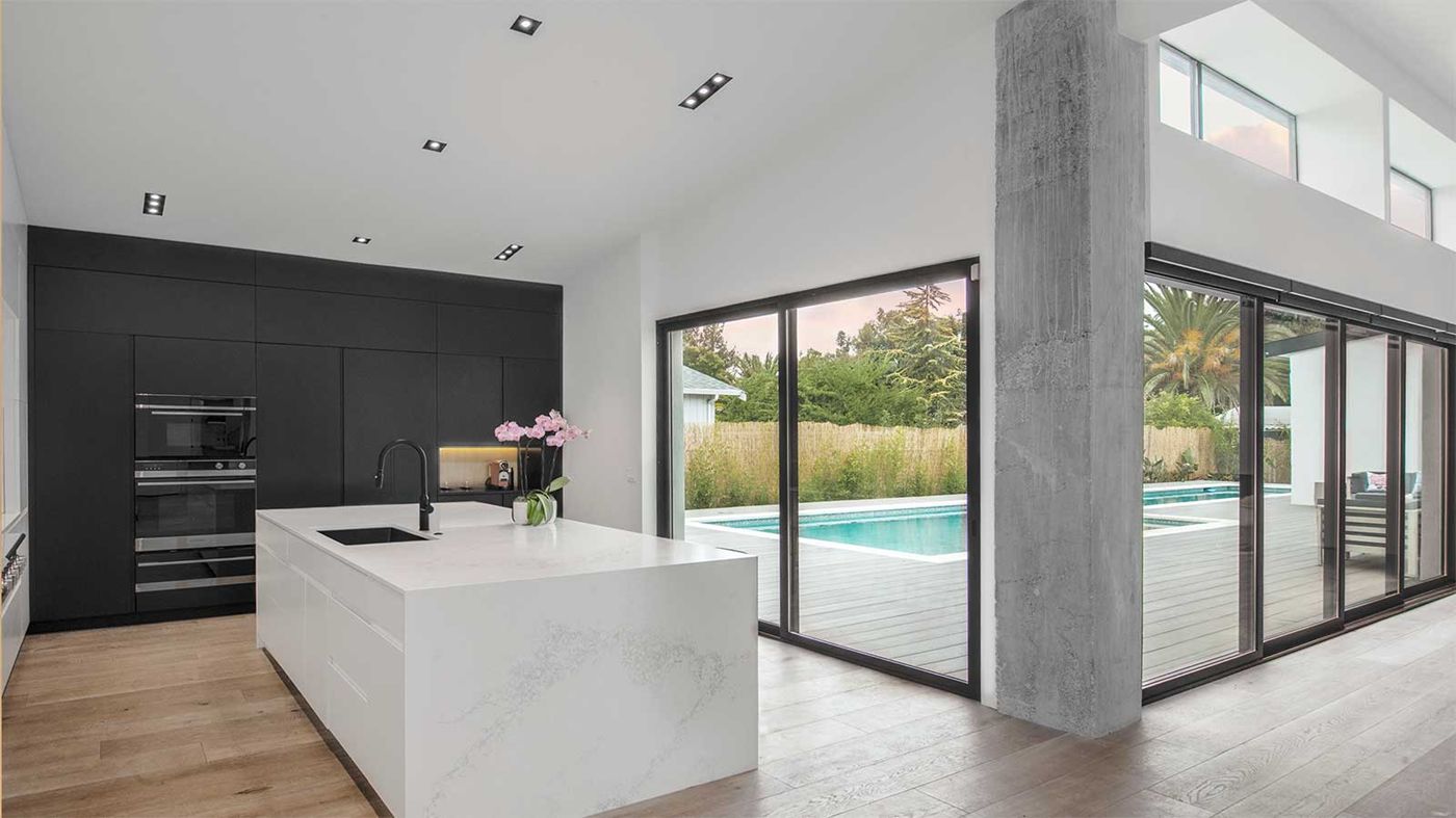 After: finished modern kitchen opening onto the pool