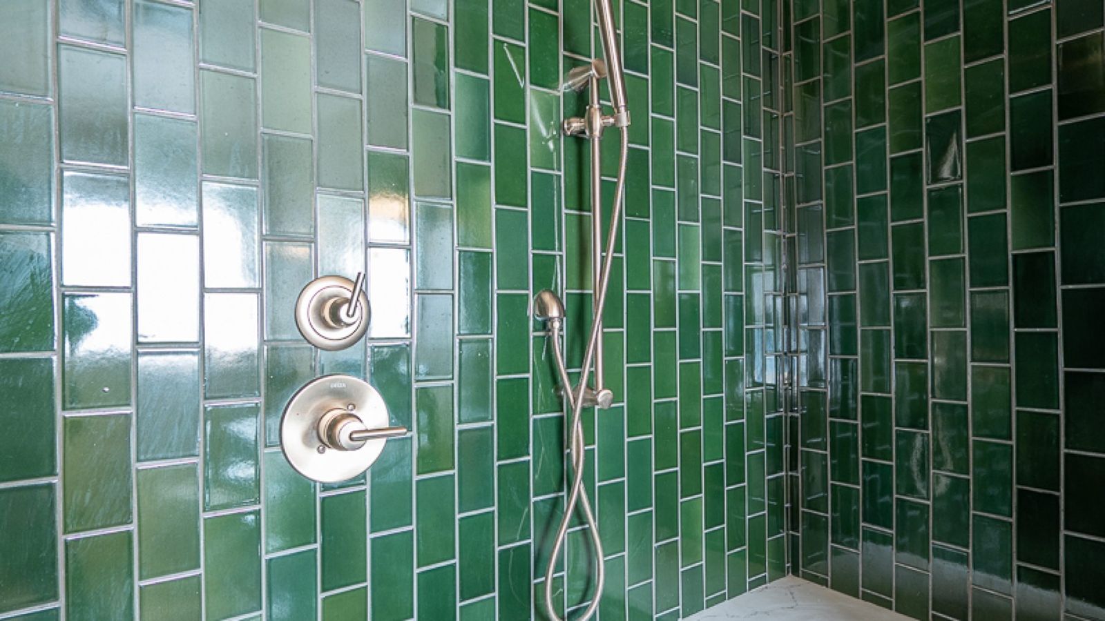 Emerald green tiled shower with brushed nickel fixtures