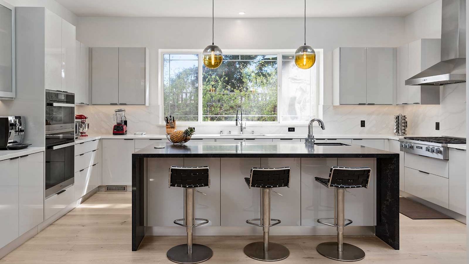 Modern white kitchen with black waterfall island